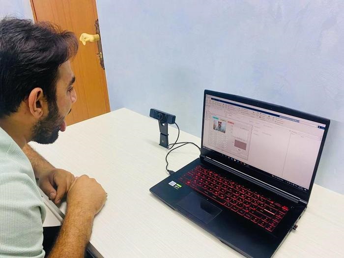 Image: A researcher demonstrates how a camera captures images of the tongue and analyses it for disease (Photo courtesy of MTU)